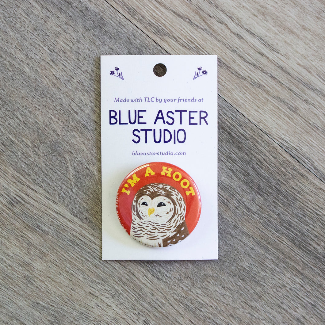 A 1.5 inch pinback button with an illustration of a barred owl with the words 