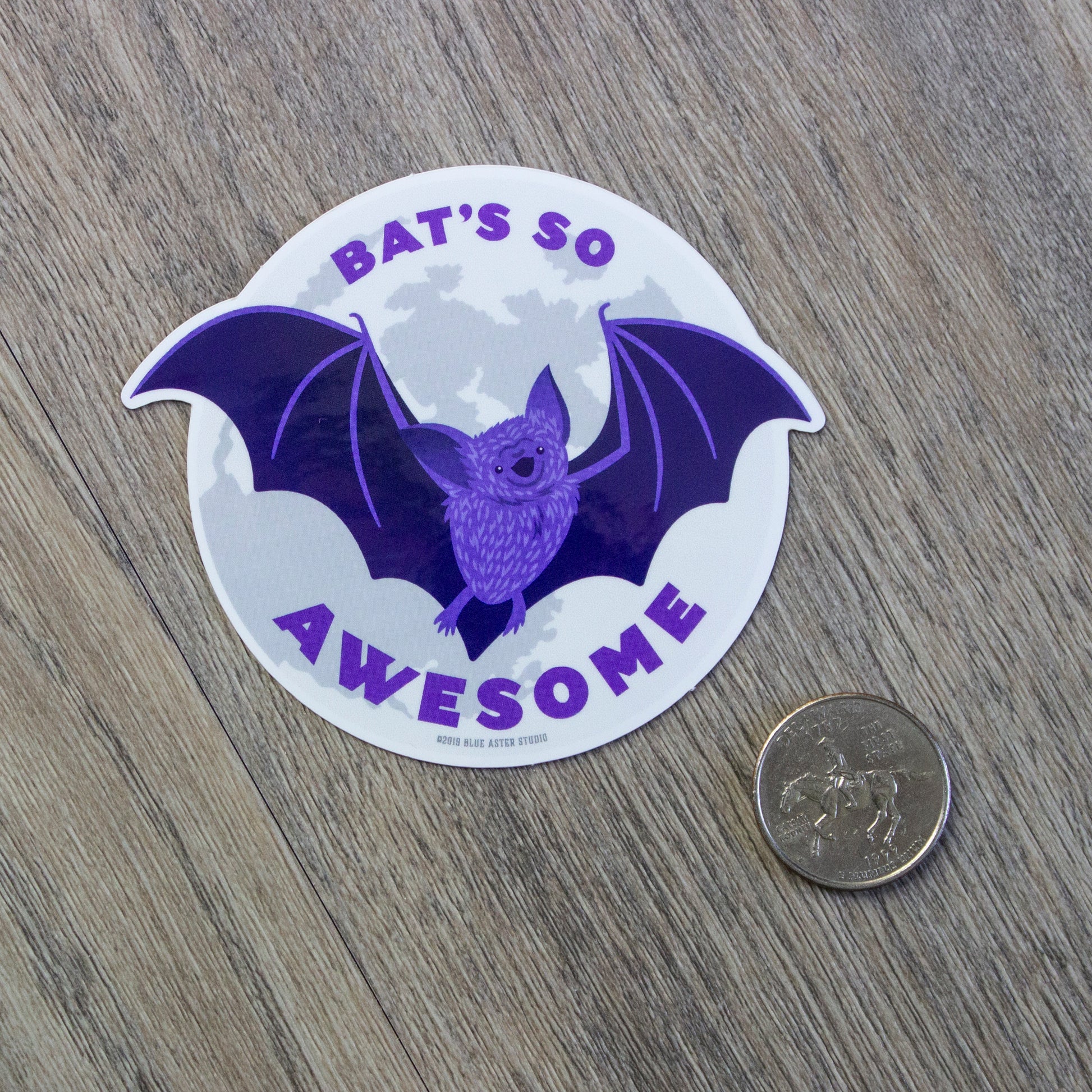 The bat sticker next to a USD quarter for size comparison.