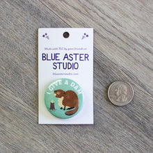 Load image into Gallery viewer, The 1.5 inch beaver &quot;I Give A Dam&quot; button next to a USD quarter for scale.