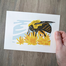 Load image into Gallery viewer, A bumblebee art print being held by a hand to show scale.