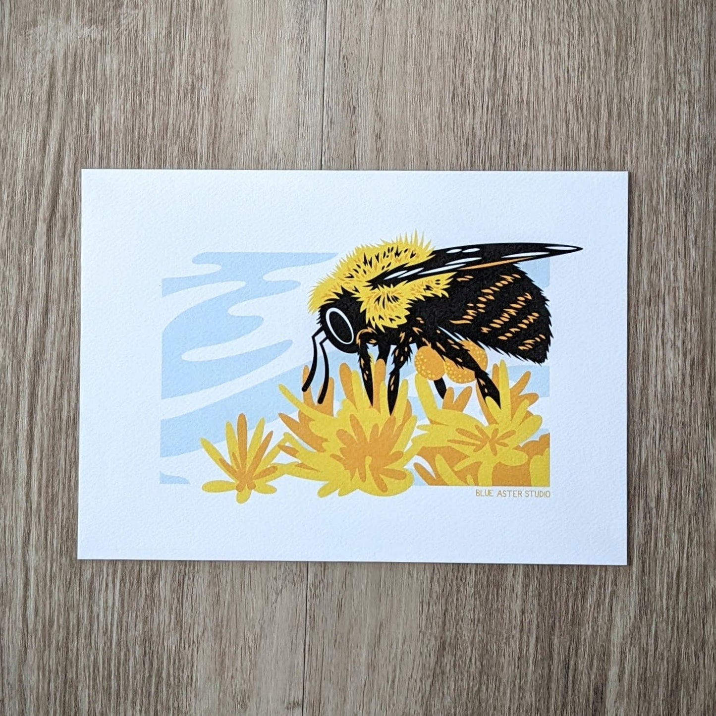 A 5x7 art print of an illustration of a bumblebee on some yellow and gold flowers.