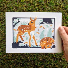 Load image into Gallery viewer, A hand holding a 5x7 inch art print of two fawns in a woodland scene.