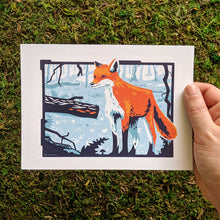 Load image into Gallery viewer, A hand holding a 5x7 inch art print of a fox in a frozen forest setting.