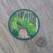 Load image into Gallery viewer, A Hit The Trail vinyl sticker next to a USD quarter for scale.