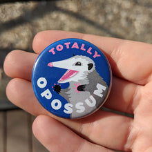 Load image into Gallery viewer, A hand holding the opossum pinback button showing more close up details of the opossum illustration.