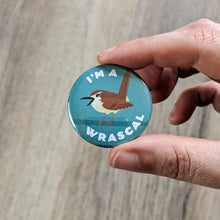 Load image into Gallery viewer, Hand holding the Wren I&#39;m A Wrascal button to show close-up of the wren illustration.
