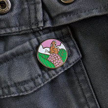 Load image into Gallery viewer, A round monarch butterfly enamel pin on a gray canvas jacket.