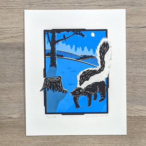 An 8 by 10 inch screen print of a skunk walking in a field in the moonlight past a tree and a stump. It is printed in two shades of blue, gray, and black.