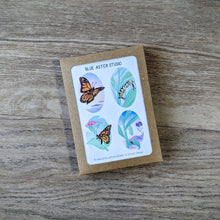 Load image into Gallery viewer, A monarch stationery set including four designs featuring monarch butterflies, a monarch caterpillar, and a monarch chrysalis. The monarch card set includes eight total cards with envelopes and is packaged in a kraft paper box.