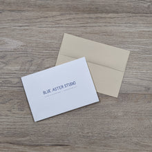 Load image into Gallery viewer, The back of the rabbit card showing the Blue Aster Studio logo, website address, and that the cards are printed on recycled paper. The card is sitting next to the natural brown envelope.