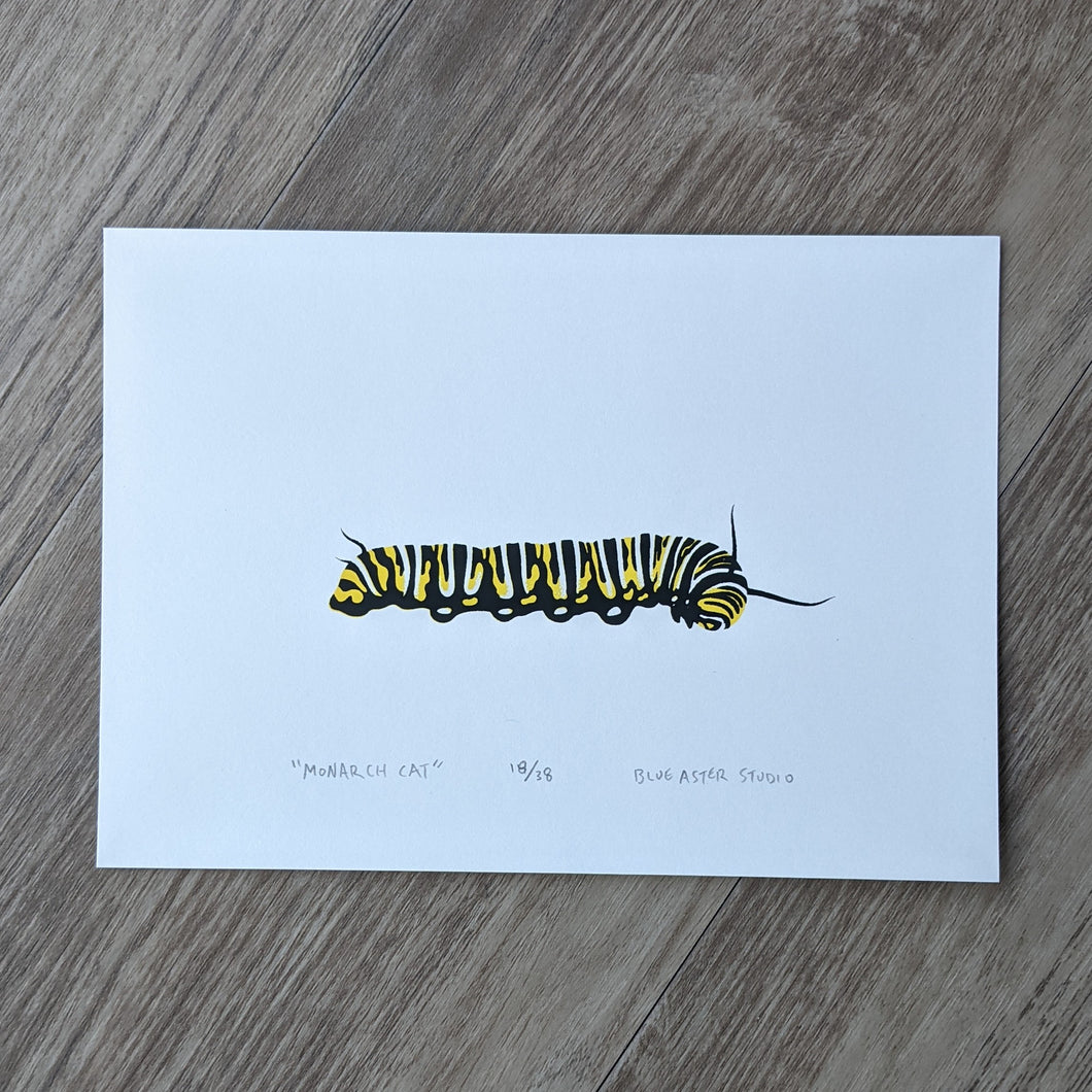 A screen print of a monarch caterpillar printed in two colors of yellow and black.
