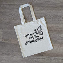 Load image into Gallery viewer, An organic cotton tote bag with the words &quot;Plant More Milkweed&quot; and a monarch butterfly in flight printed on it in black.