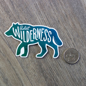 The Protect Wilderness Wolf sticker sitting next to a USD quarter to show scale.