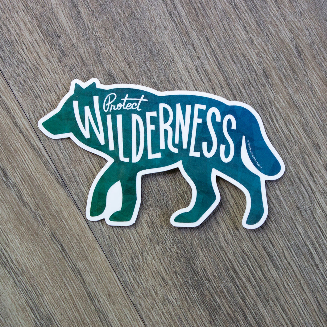 A vinyl sticker in the shape of a wolf silhouette with the words Protect Wilderness.