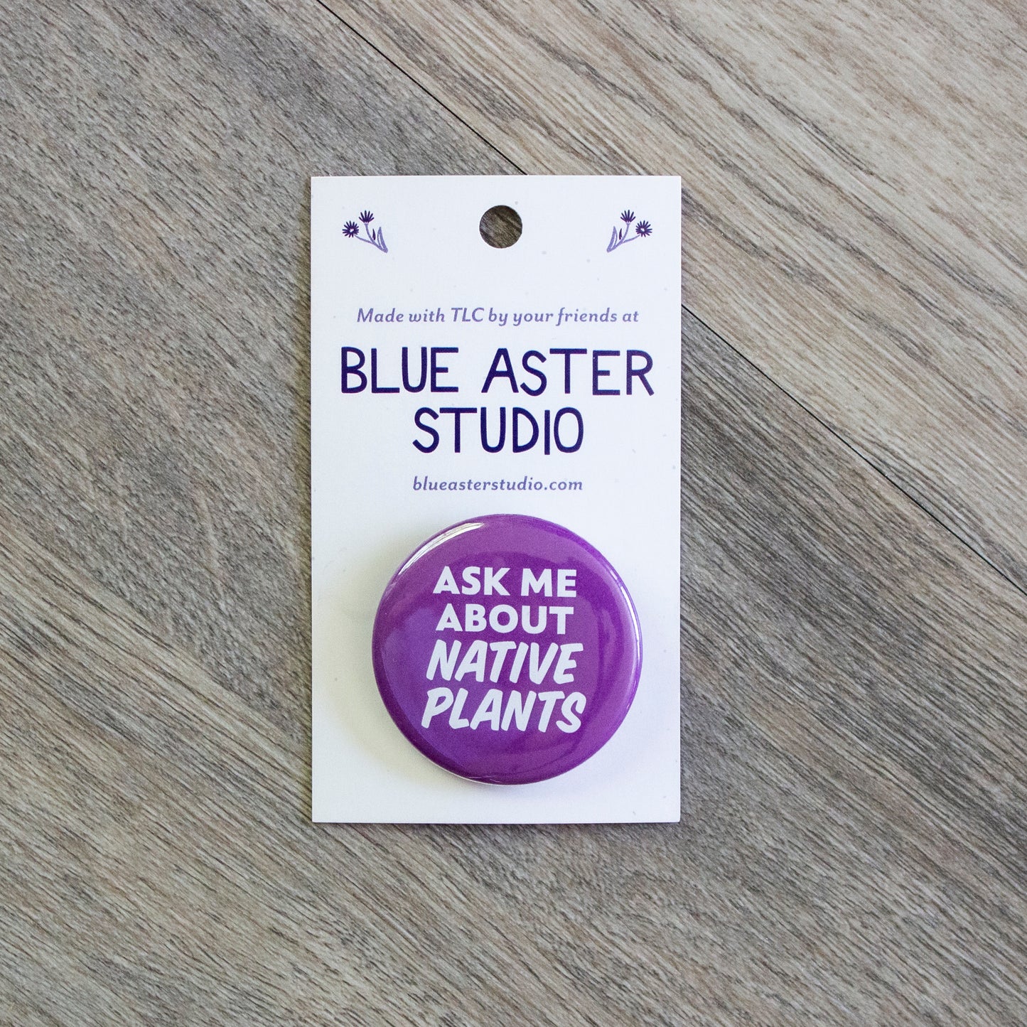 A 1.5 inch purple pinback button with the words Ask Me About Native Plants in white