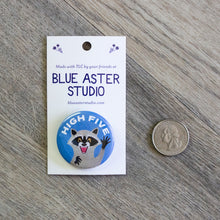 Load image into Gallery viewer, The 1.5 inch raccoon button next to a USD quarter for scale