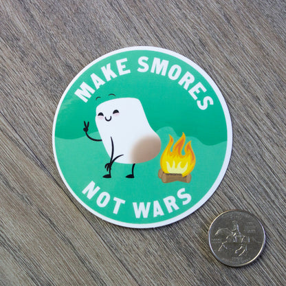 The Make Smores Not Wars vinyl sticker sitting next to a USD quarter for scale.