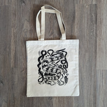 Load image into Gallery viewer, A sturdy canvas tote bag with woven handles featuring an illustration of a collection of seven snakes native to the eastern United States. The snakes include a timber rattlesnake, black rat snake, eastern hognose, ringneck, water snake, garter snake, and ribbon snake.