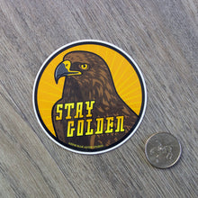 Load image into Gallery viewer, The golden eagle Stay Golden sticker sitting next to a USD quarter to show scale.