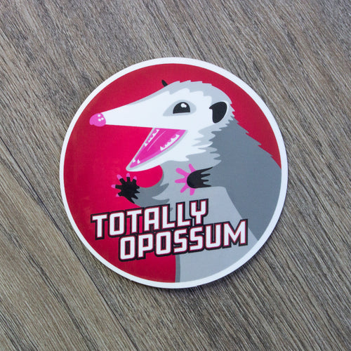 A round vinyl sticker with an illustration of an opossum with a red background and the words Totally Opossum.