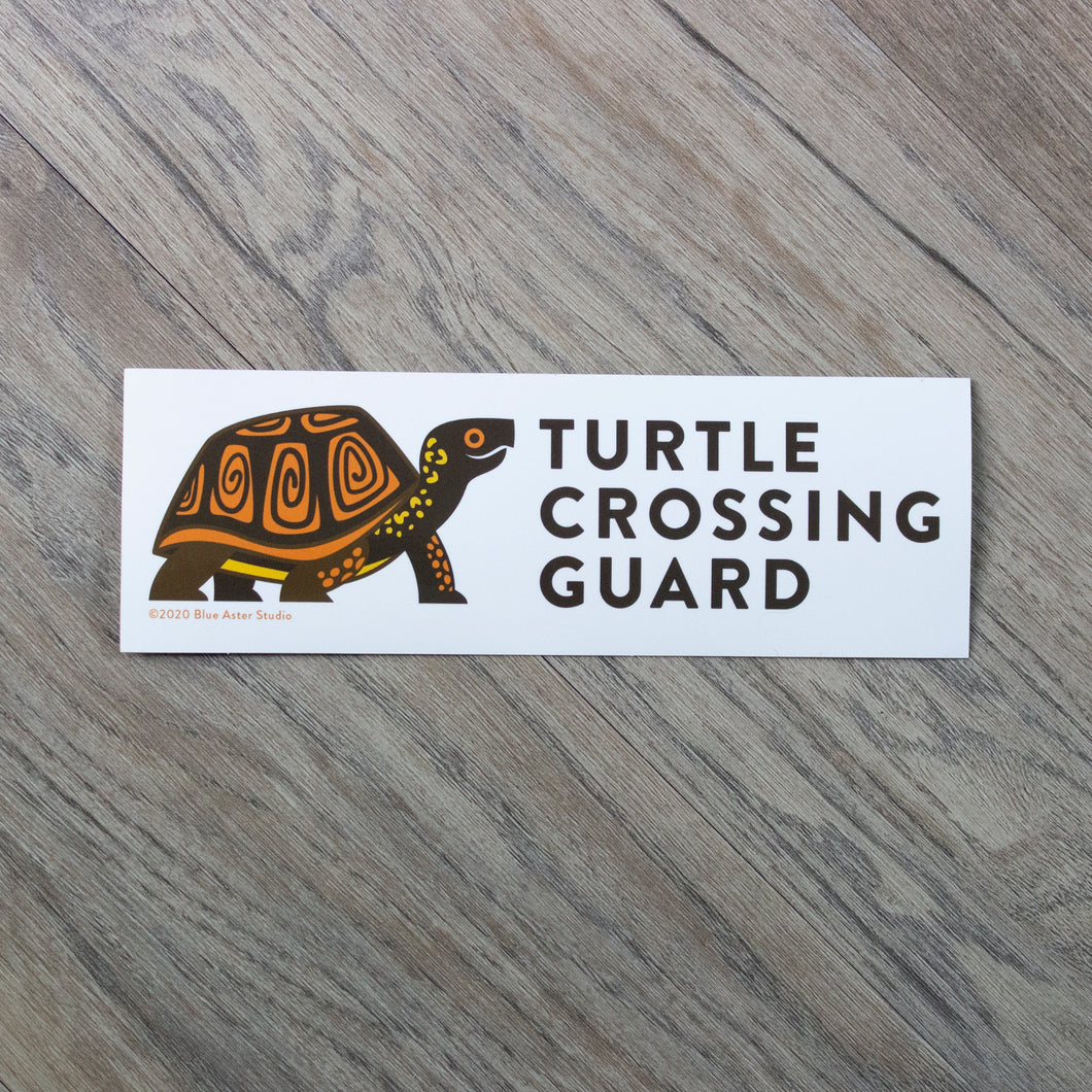 A 2.5 by 7.5 inch white vinyl bumper sticker with an illustration of a box turtle and the words 
