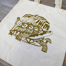 Load image into Gallery viewer, A close up of the screen printed turtle design on the durable organic cotton tote bag. This turtle tote bag features a turtle surrounded by native woodland plants.