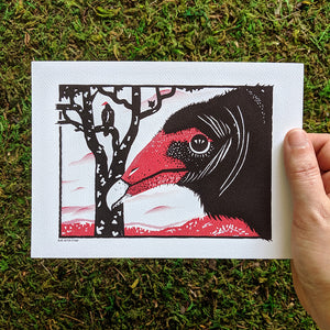 A hand holding a 5x7 inch art print of a turkey vulture illustration.