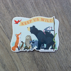 A vinyl sticker with an illustration of a fox, rabbit, turtle, owl, raccoon, bear, opossum, snake, and bird holding a flag that reads "Keep Us Wild"