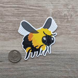 A vinyl sticker of a bumblebee sitting next to a USD quarter to show scale.