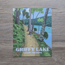 Load image into Gallery viewer, An art print featuring an illustration of a hiking trail at Griffy Lake Nature Preserve. The illustration shows a hiking trail along Griffy Lake with trees, ferns, and mushrooms along the path. In the distance you can see a goose swimming in the water and the other shoreline.