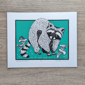 An illustration of a raccoon in a patch of chanterelle mushrooms with a teal background. This is an original Blue Aster Studio screen print that is signed and numbered.